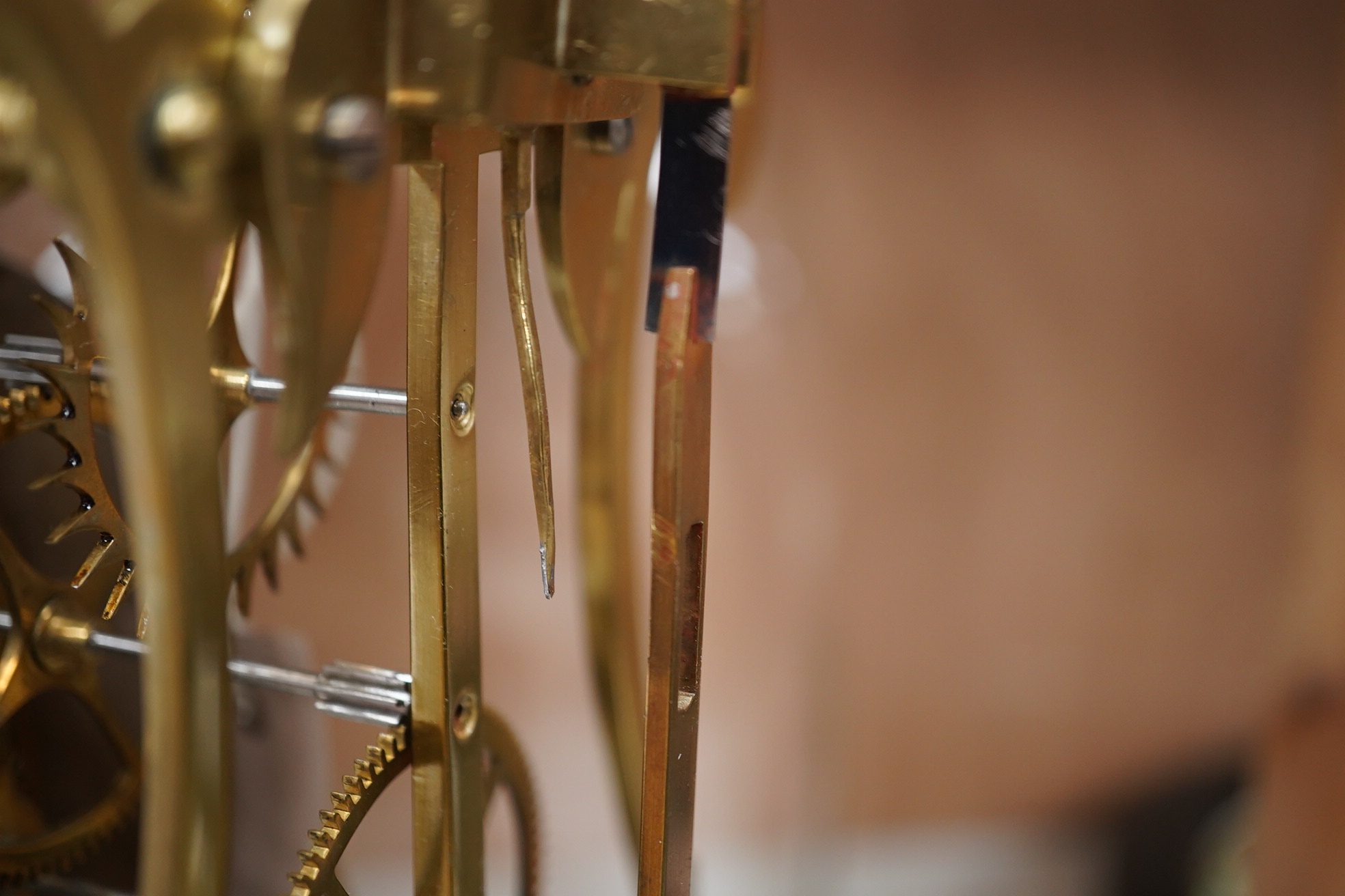 A late 19th century brass skeleton timepiece, the silvered chapter ring with Roman numerals, on a stand, under a glass dome, 37cm high. Condition - pendulum adjustment needed